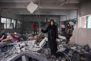 A woman stands in the debris at the Fahmi al-Jarjawi school following an Israeli airstrike