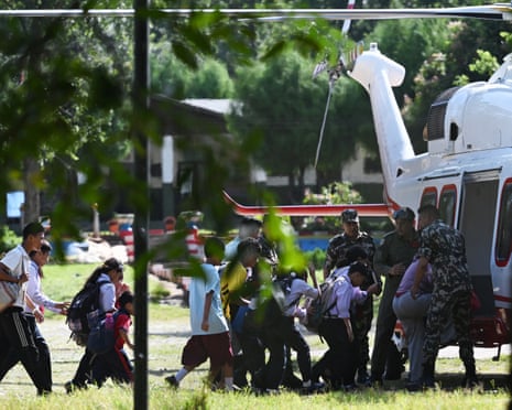 School children board a helicopter on a transit flight back to their family at Trishuli camp after being stranded by the flash flooding in Nepal's Nuwakot district