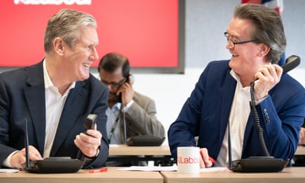 Keir Starmer and Feargal Sharkey laughing together while holding phone receivers