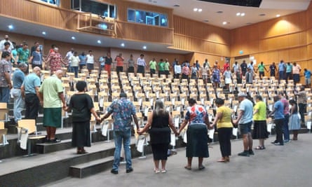 Staff at the University of the South Pacific Laucala campus in Suva, Fiji, stand together in. prayer for their deported vice-chancellor, Professor Pal Ahluwalia and his wife, Sandra Price.