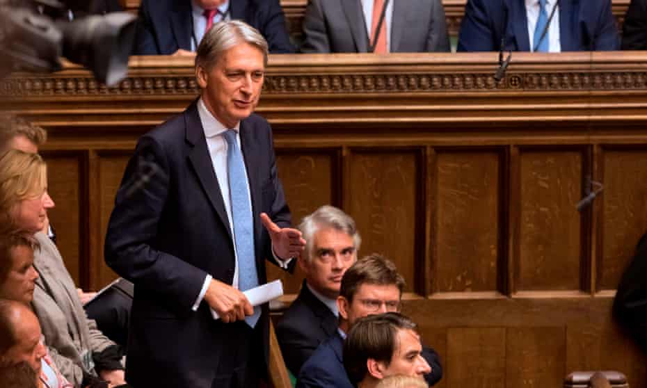 Philip Hammond standing to speak in the Commons in 2019, gesturing with one hand and with a rolled-up piece of paper in the other