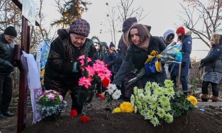 People lay flowers during the funeral ceremony of writer Volodymyr Vakulenko, who was murdered by the Russian military in March last year.