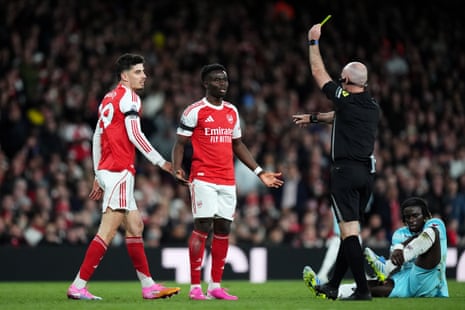 rsenal's Kai Havertz (left) is shown a yellow card by referee Paul Tierney.