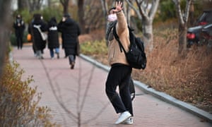 A student waves to her mother as she walks to an exam room to take the annual College Scholastic Ability Test, a standardized exam for admission to the university, on December 3, 2020.