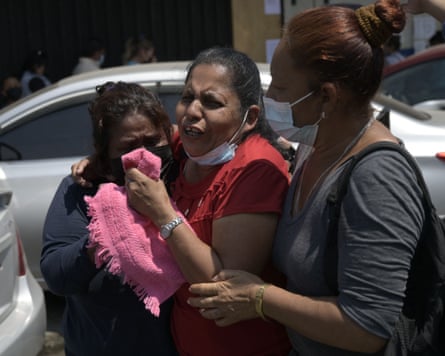 A crying woman is held by two other women