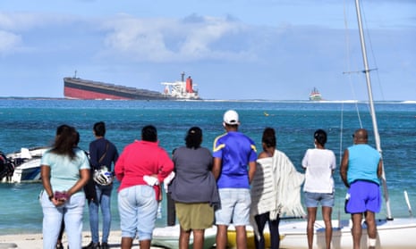 People gather to look at the stranded MV Wakashio ship which is leaking oil.