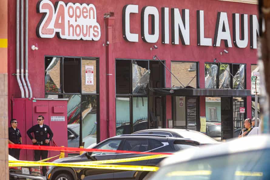 Two police officers are outside a red building with a sign that says