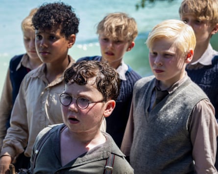 Group of boys in school uniform stand near sea