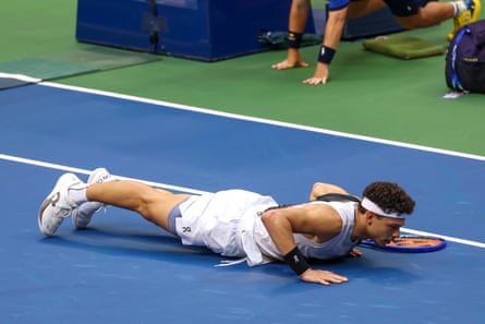 Ben Shelton face down on the court after a gruelling rally