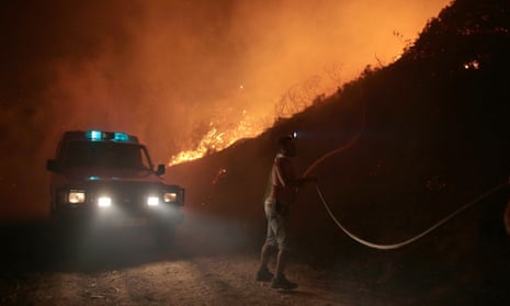 A firefighter tries to extinguish a forest fire in the Serra de Bouro district of Leiria, north of Lisbon, Portugal.