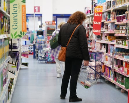 An anonymous shopper in a supermarket aisle
