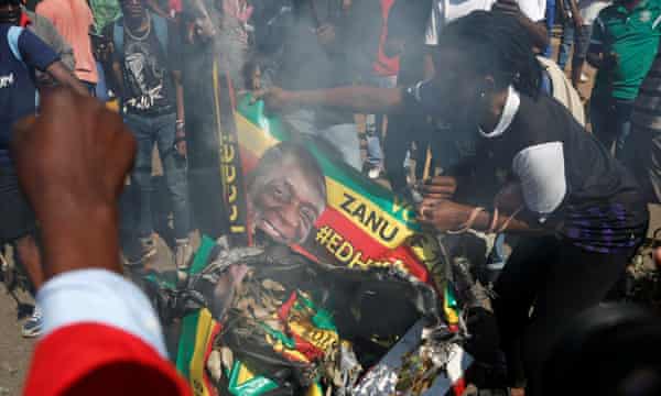 Supporters of the opposition MDC burn an election banner bearing the face of Emmerson Mnangagwa in Harare.
