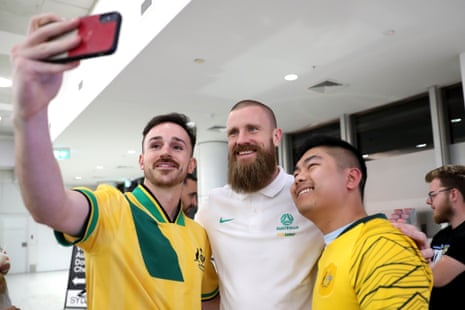 Andrew Redmayne of the Socceroos poses for a selfie with fans at Sydney Airport.