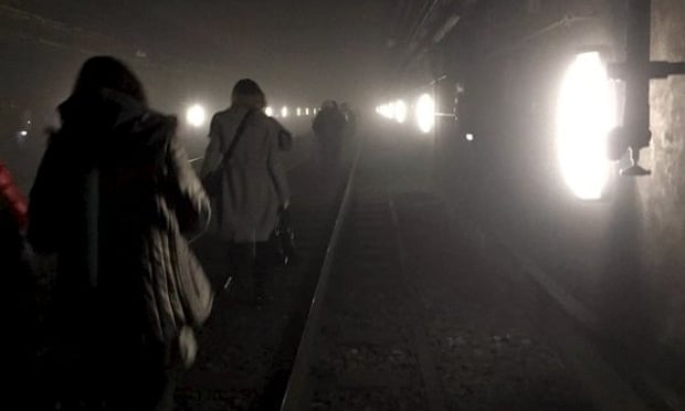 Passengers walk on Metro tracks to be evacuated after an explosion at Maelbeek train station in Brussels.