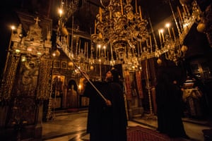 A monk lights candles during a midnight vigil. Monks usually pray in the early hours of the morning as they believe this is when they are closer to God and their prayers can be heard.