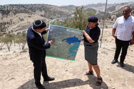 Bezalel Smotrich holds up a map showing the planned E1 settlement