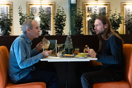 Philip and Carl chatting and eating at a restaurant table