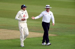 Joe Root and umpire Richard Kettleborough talk as they leave the pitch for a rain delay.
