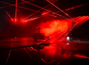 Red strobe lights and dry ice surround the rapper Travis Scott as he performs on top of an electric G-Class Mercedes in Los Angeles at the vehicle's launch