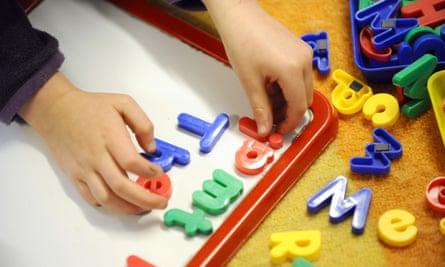 small child's hands playing with plastic letters
