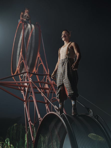 Two men balancing on a double spinning wheel