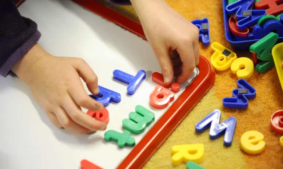 Young child plays with plastic letters