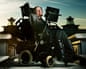 Professor Stephen Hawking sits in his motorized wheelchair with mounted computer screen on a rooftop at dusk