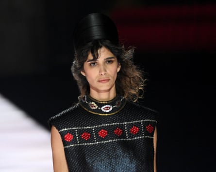 A model in black jewelled top and tall black hat
