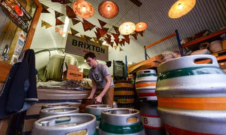A brewer labels casks of Effra Ale at Brixton Brewery 