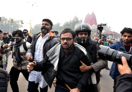 Umar Khalid is detained by a police officer