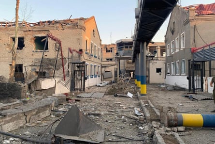 Wrecked prison buildings and debris in courtyard