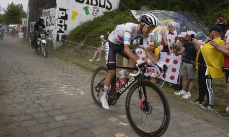 Slovenia's Tadej Pogacar, wearing the best young rider's white jersey, rides on the cobblestones during a  frenzied stage. 