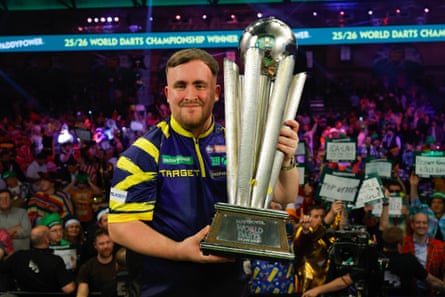 Luke Littler holds the trophy aloft after winning his second world title.