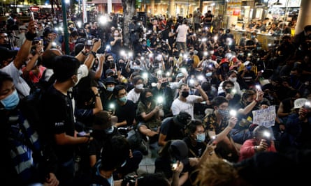 Thai students and pro-democracy activists activate torches on their phones during the rally in Bangkok.