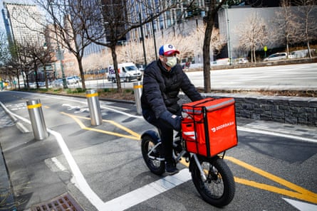 A DoorDash delivery driver transports food on a bike