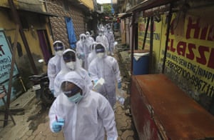 Health workers arrive to administer a free medical checkup in a slum in Mumbai, India