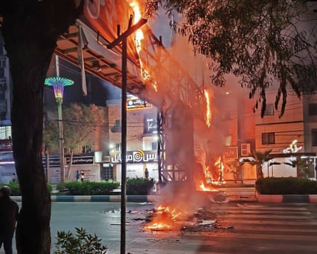 A metal structure built over a road burns in the city