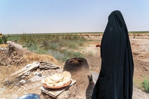 A women cooking flatbread outside.