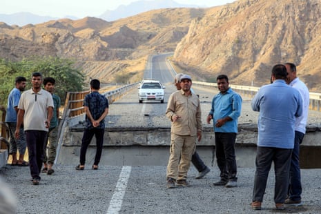 Officials inspect a heavily-damaged bridge which was hit by a US strike along the road connecting Roudan and Bandar Abbas in southern Iran on July 18, 2026.