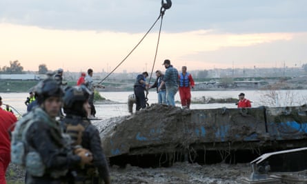 Iraqi civil defence workers recover the ferry that sank in the Tigris, 23 March 2019