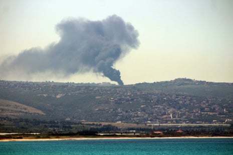 Black smoke rises into the sky from a distance.
