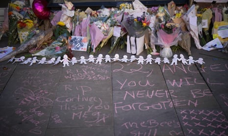 Floral tributes and messages written in pink chalk on the ground