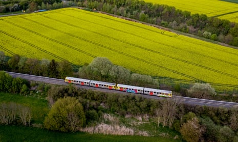 A regional train passes fields of rapeseed plants in Wehrheim near Frankfurt, Germany.