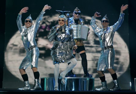 Verka Serduchka and her band, dressed in silver dresses, dance