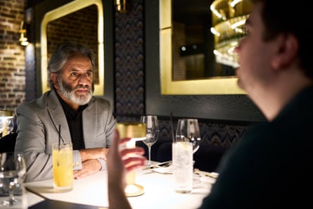 Two men facing each other across a restaurant table