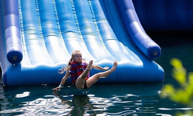 Girl flies off an inflatable slide to land in the water