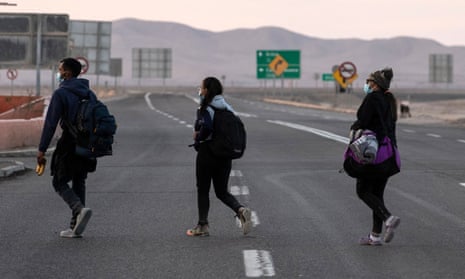 Venezuelan migrants walk along the highway on their way to Iquique, after crossing from Bolivia, in Colchane, Chile. 