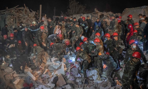 Rescue teams work at a site hit by a strike during fighting over the breakaway region of Nagorno-Karabakh, in the city of Ganja.