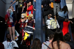 People dressed as Harley Quinn from Suicide Squad ride an escalator on the subway