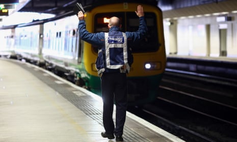 A Network Rail employee signals to the driver as a train arrives at Birmingham New Street station